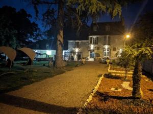 a house lit up at night with a driveway at Gîte la Baronnière in Saint-Avertin
