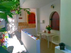 Habitación con mesa, sillas y 2 ventanas en Kastro Studios Apartments, en Myrtos