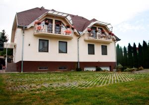 a large house with two balconies on a yard at Varga Apartmanház in Zalakaros