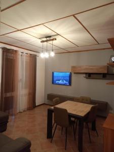 una sala da pranzo con tavolo e TV a parete di Casa vacanza Petrari Residence Alt Air a Ovindoli