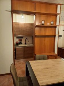 cocina con mesa, sillas y fregadero en Casa vacanza Petrari Residence Alt Air, en Ovindoli