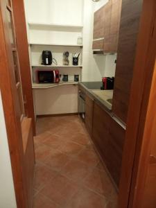 Elle comprend une petite cuisine avec des placards bruns et du carrelage. dans l'établissement Casa vacanza Petrari Residence Alt Air, à Ovindoli