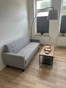 un salon avec un canapé et une table basse dans l'établissement One100 I Appartment am Schaufenster Fischereihafen, à Bremerhaven