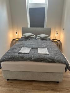 um quarto com uma cama com duas toalhas em One100 I Appartment am Schaufenster Fischereihafen em Bremerhaven