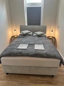 une chambre avec un lit avec deux serviettes dessus dans l'établissement One100 I Appartment am Schaufenster Fischereihafen, à Bremerhaven
