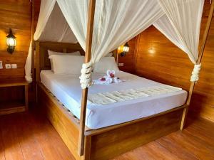 a bedroom with a bed with a teddy bear on it at Ings Garden in Gili Islands