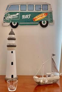 ein Spielzeug-Van und ein Leuchtturm auf dem Tisch in der Unterkunft Atlantic Bay in Costa da Caparica