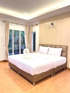 a bedroom with a large bed with white sheets at Koh Yao Modern Inn -SHA Plus in Ko Yao Yai