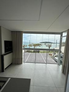 a large living room with a view of the ocean at Apartamento Frente Mar na Baía de Porto Belo in Porto Belo