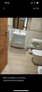 een badkamer met een witte wastafel en een toilet bij Apartamentos Boutique Arquera Golf I in Llanes