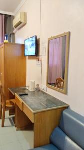 Habitación hospitalaria con mesa y espejo en SUSAN HOTEL SEAFRONT, en Sandakan