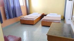 Habitación con 2 camas y mesa. en SUSAN HOTEL SEAFRONT, en Sandakan