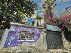 een gebouw met een paarse poort en bloemen erop bij Citadin Yurrita in Guatemala