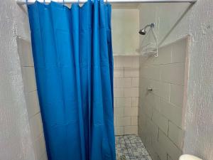 een douche met een blauw douchegordijn in een badkamer bij Citadin Yurrita in Guatemala +10 foto's