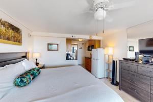 a bedroom with a white bed and a refrigerator at Island Colony 3715 in Honolulu