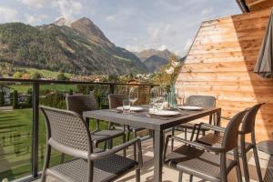 stół i krzesła na balkonie z widokiem na góry w obiekcie AlpenParks Montana Apartments w mieście Matrei in Osttirol