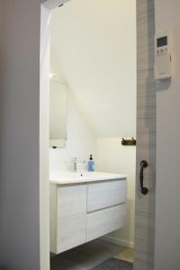 a white bathroom with a sink and a mirror at Gîte La Capucine in Saint-Avertin