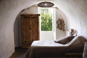 a bedroom with a bed and an open window at Chambre d'Hôtes La Marlotte in Castello-di-Rostino