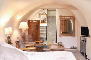 a bedroom with a bed and a living room at Chambre d'Hôtes La Marlotte in Castello-di-Rostino