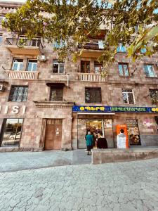 a building with people walking in front of it at Apartment in Monument in Yerevan