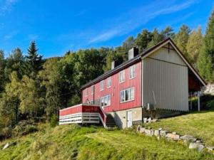 eine rote Scheune auf einem Hügel in der Unterkunft Holiday home Snillfjord II in Snillfjord