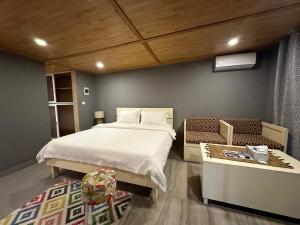 1 dormitorio con 1 cama y un banco en una habitación en Tropicana Beach & Resort en Elwa