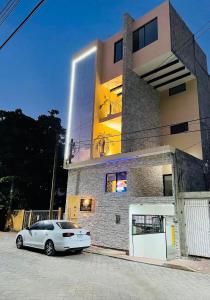 a white car parked in front of a building at Hotel Casa María Tamasopo in Tamasopo