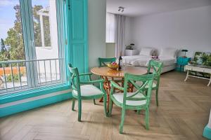 Zimmer mit einem Tisch, Stühlen und einem Bett in der Unterkunft Inn & Art Madeira in Caniço