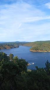 a view of a large lake with a boat in it at Hotel Da Montanha in Pedrógão Pequeno