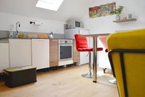 eine Küche mit einem Tisch und einem roten Stuhl in der Unterkunft Gîte le Saint-Honoré in Saint-Avertin