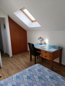 um quarto com uma secretária, um lavatório e uma cama em La Chataigneraie em Vernouillet