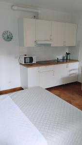 eine Küche mit weißen Schränken und einer Arbeitsplatte in der Unterkunft La Corte di Vicolo Torre in Uboldo
