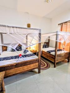 a bedroom with two bunk beds with mosquito nets at Mkadi Beach House in Nungwi