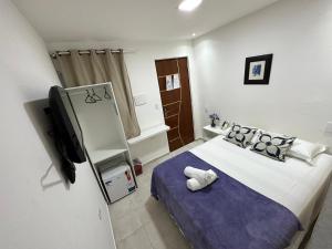 1 dormitorio con 1 cama y TV. en Pousada Maresia, en Maragogi