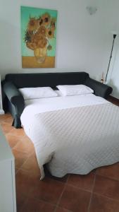 1 dormitorio con 1 cama grande y edredón blanco en La Corte di Vicolo Torre, en Uboldo