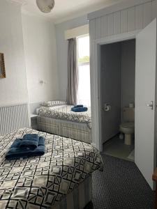 a bedroom with two beds and a bathroom with a window at earlsmere hotel in Hull
