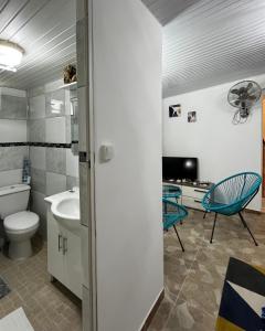 ein Bad mit einem WC, einem Waschbecken und einem TV in der Unterkunft Logis Colibri du Morne Jacob, Le Morne-Rouge Martinique in Le Morne Rouge
