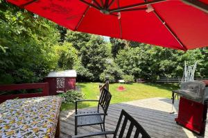 un patio con sombrilla roja, mesa y sillas en Cheerful 3 bedroom, 2 car garage, huge backyard, en Newmarket