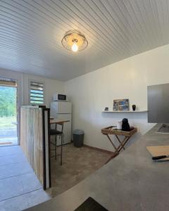 ein Wohnzimmer mit einem Tisch und einem Schreibtisch in der Unterkunft Logis Colibri du Morne Jacob, Le Morne-Rouge Martinique in Le Morne Rouge