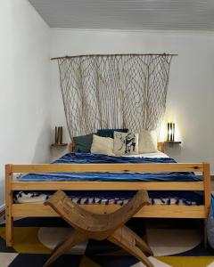 Schlafzimmer mit einem Bett mit einem Kopfteil aus Holz in der Unterkunft Logis Colibri du Morne Jacob, Le Morne-Rouge Martinique in Le Morne Rouge