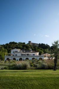 a large white house with a castle on the hill at Vigna Caio Relais & Spa in Bracciano
