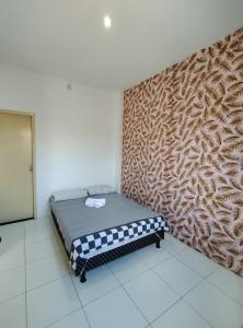 uma cama num quarto com uma parede em Apto 2/4 completo em Serrinha