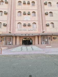 un grand bâtiment avec un panneau à l'avant dans l'établissement شقق درة الصالحين, à La Mecque