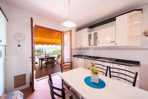 eine Küche mit einem Tisch, Stühlen und einem Tisch in der Unterkunft Residence Le Grazie Est in Capoliveri