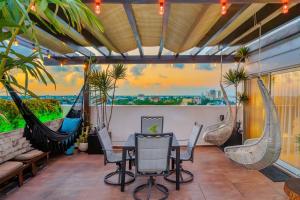 un patio con amache, tavolo e sedie di Luxury 4 Bedroom Penthouse with Private Jacuzzi steps from hotel zone a Cancún