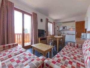 a room with two beds and a kitchen with a table at Les Aiguilles De Warens in Combloux