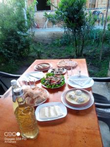 Green Villa Tskaltubo في تسكالتوبو: طاولة مع أطباق من الطعام وزجاجة من البيرة
