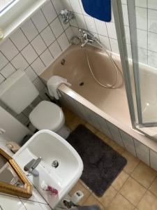 a bathroom with a sink and a toilet and a tub at Schöne 2,5 Zimmer Wohnung in Dortmund-Hörde Phönix! in Dortmund