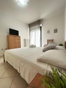 a bedroom with a large bed and a television at San Martino-Flexrent Immobiliare Abissinia in Riccione