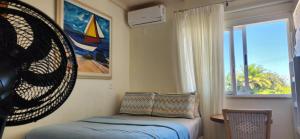 ein kleines Schlafzimmer mit einem Bett und einem Fenster in der Unterkunft Village Itacimirim Summer Houses in Itacimirim